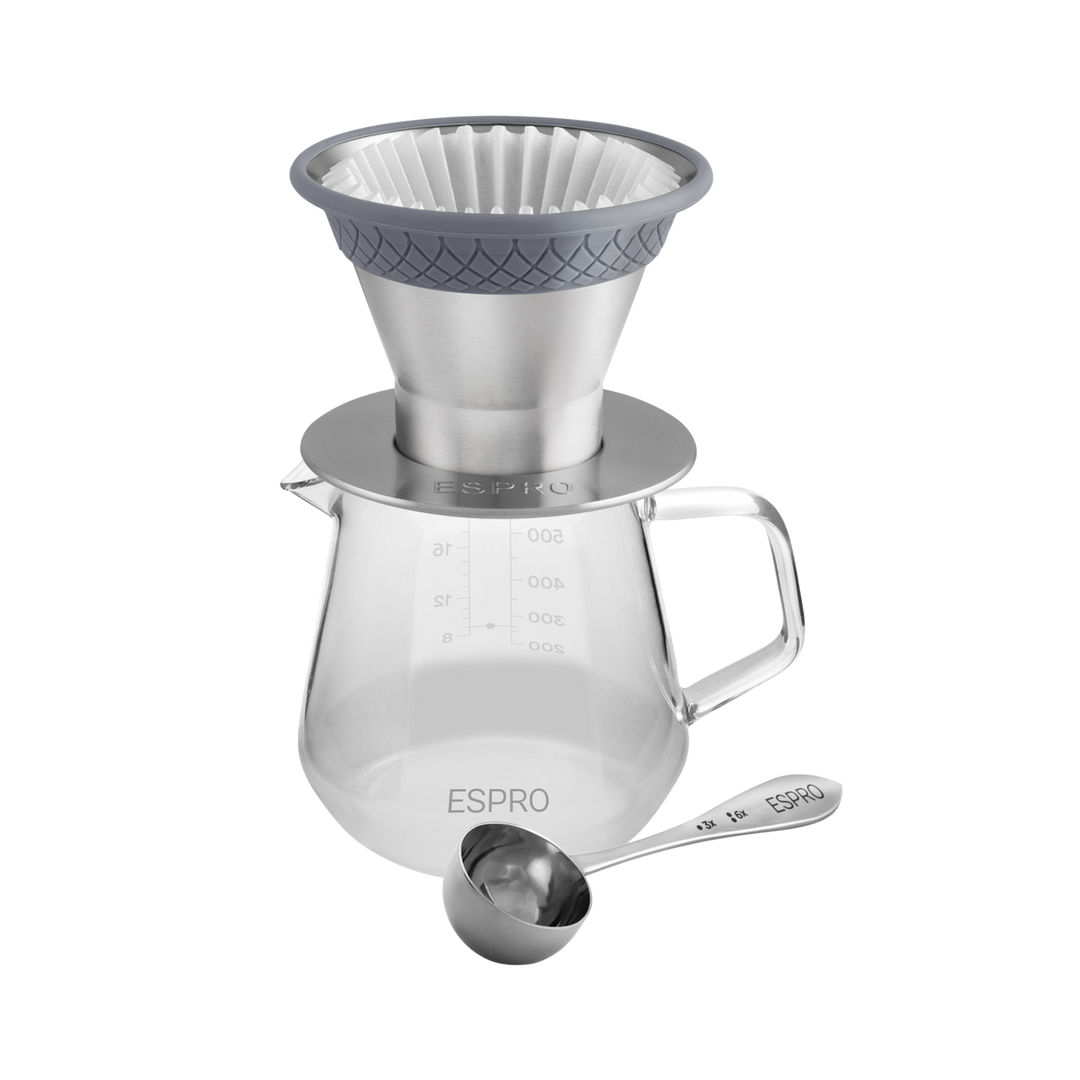 Pour over dripper on top of a carafe w/ a coffee measuring spoon next to it