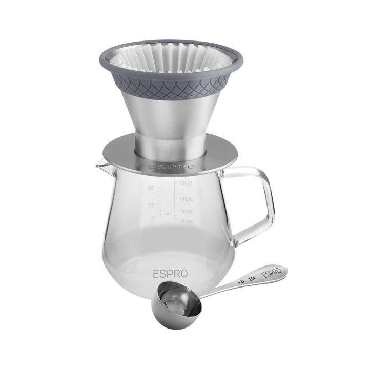 Pour over dripper on top of a carafe w/ a coffee measuring spoon next to it